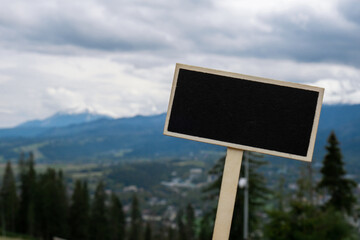 Empty blackboard label with copy space on background of Snowy mountains, green forests In National park Zakopane Poland. Mountain nature landscape. Travel outdoors green tourism concept Naturecore