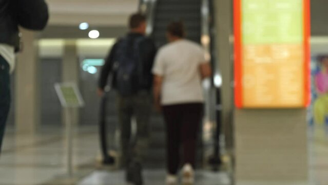 people hurry. blurry people in a modern shopping center building enter and climb the escalator. abstract blur background of modern sity life.