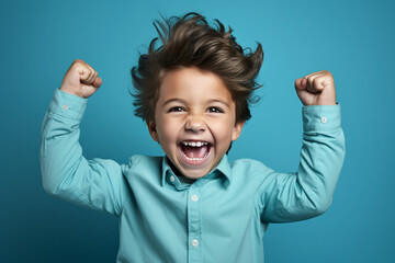 happy winner school boy isolated on blue background celebrates new success, power, energy. Yes !