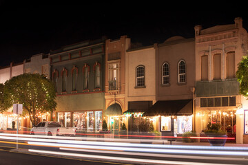 Fototapeta na wymiar Night time traffic streams through historic downtown Red Bluff, California, USA.