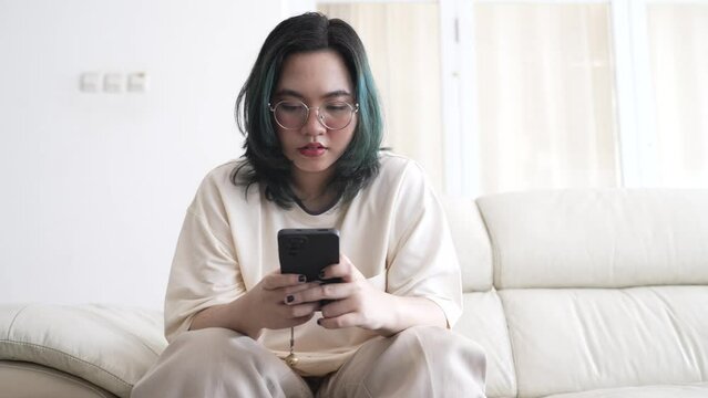Woman typing write message on smart phone at homesofa