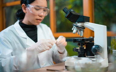 Medical Research Laboratory. Female Scientist Using Microscope to analyze substance or liquid.