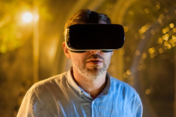Man in VR glasses inside a glamping tent at night