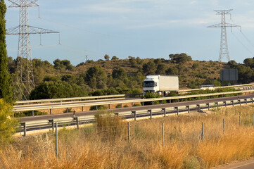 Semi truck with Semi-trailer driving along highway. Goods Delivery by roads. Services and Transport logistics. Highway with transport, car and truck, road landscape. Road traffic on motorway.