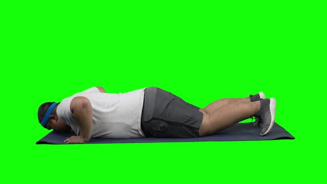 Overweight Asian guy doing push up over green screen background f