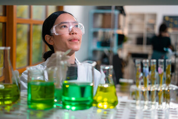 Asian woman scientist plant science laboratory research, biological chemistry test, green nature organic leaf experiment in test tube.