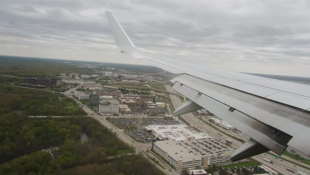 Wing of the plane and clouds, view from the plane. Landing in Chicago O'hare airport. Wide shot