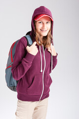 Teenager Lifestyle. Winsome Calm Caucasian Teenager Girl With Teeth Brackets Posing in Hoodie With Backpack Over White.