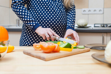Obraz na płótnie Canvas Closeup of Hands of Pregnant Woman Preparing Salad with Vegetables on Kitchen.