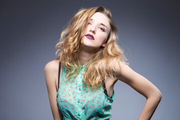Fototapeta premium Hair Ideas. Portrait of Nice Winsome Blond Caucasian Girl With Flyaways Hair. Isolated Over Gray Background.