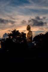 immense statue de buddha en thailande avec couché de soleil