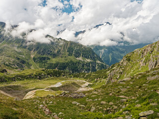 The high mountain valley in the Stubai Alps in Austria. Mountain peaks appear from among the clouds.