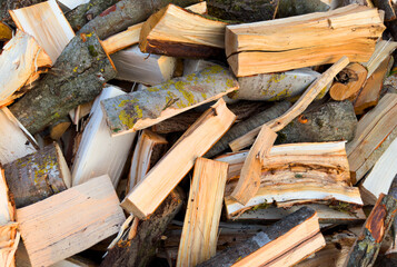 Firewood background. Chopped firewood close up. Chopping wood and cutting timber. Preparation of firewood in village for heating the house in winter.
