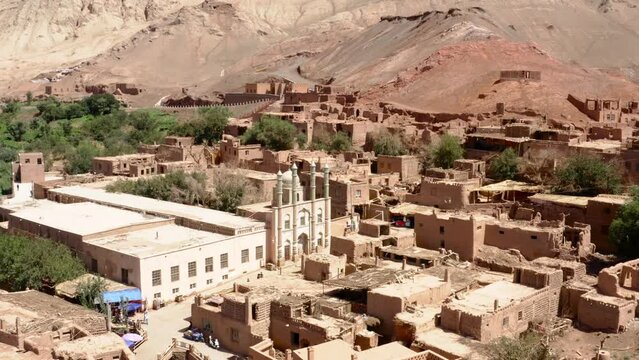 Adobe Tuyoq village in Taklamakan desert. Aerial dolly out