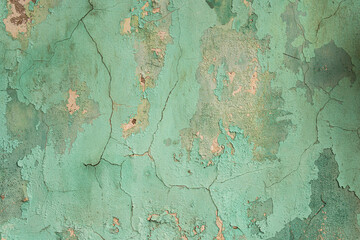 Antique concrete wall painted with green paint with cracks as texture, pattern, background