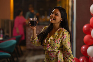 Smiling woman drinking coke at restaurant