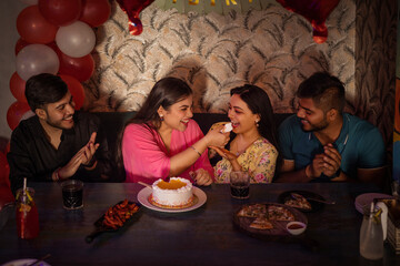 Friends celebrating birthday of their friend at restaurant 