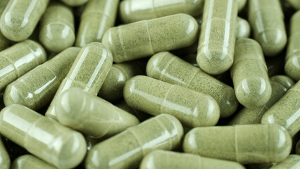 Green capsules. Superfood Capsules with green powder close up