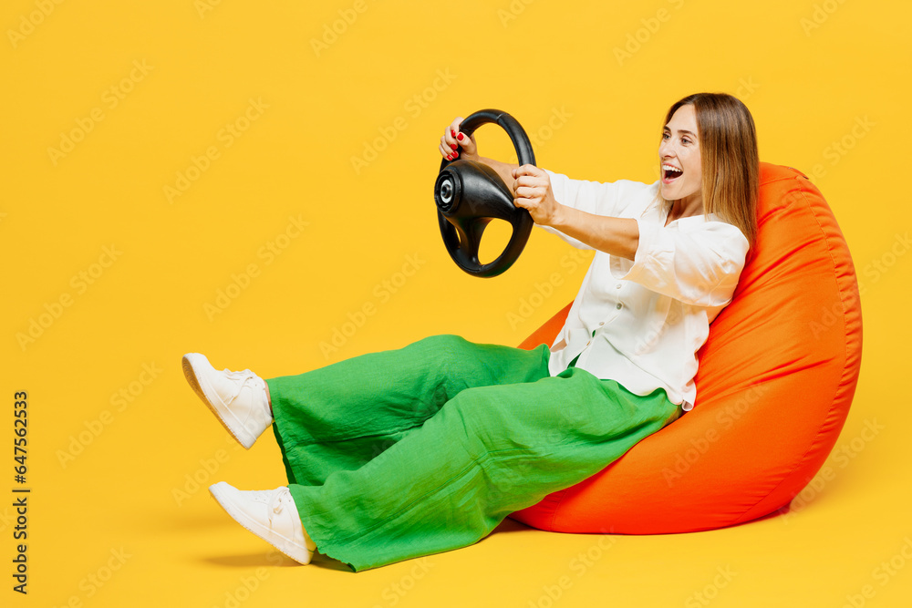 Wall mural full body side view young fun happy woman she wears white shirt casual clothes sit in bag chair hold