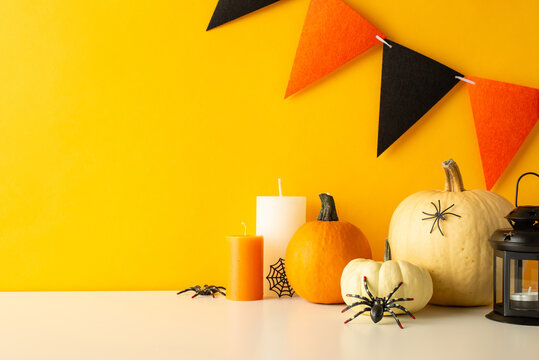 Enchant your table for Halloween. Side view image capturing tabletop adorned with themed decorations, pumpkins, gleaming lantern, spiders, cobweb, candles and festive flag garland against yellow wall