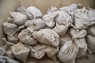 Obraz premium Sealed white sugar bags, full of garbage for disposal, located inside apartment.