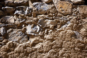 Stone antique old wall as a background or texture. Vintage background of a fortress wall in loft and grunge style with place for text and copy space.