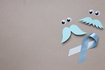 Blue ribbon with mustache and eyes, Movember concept