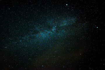 Bezchmurne niebo nocą. Nieboskłon pokrywają niezliczone gwiazdy, w centrum kadru widać...