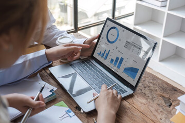 College students using laptop while sitting at table. Group study for school assignment.