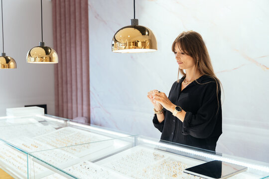 Elegant lady female entrepreneur jewelry order at workplace her assistant working with tablet looking at the leftovers, helps to place an order.