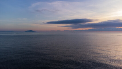 Calm sea with sunset sky and sun through the clouds over. Meditation ocean and sky background.