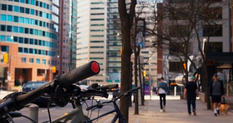Unrecognizable people downtown walk along sidewalk on main street of city bicycle stands on...