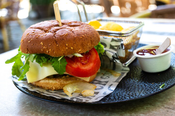 Classic hamburger with lettuce and tomatoes, servid with chips and a ketchup sauce, Belgium