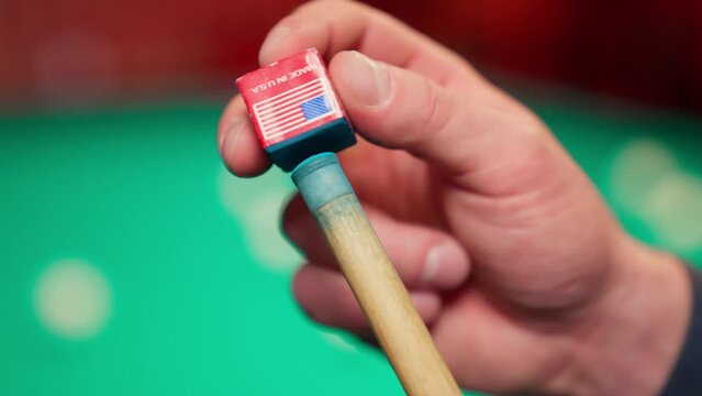 A young man plays American billiards. Russian billiards, an American in a billiards club and bar. Dark colors in the billiard club. A man pockets snooker balls.