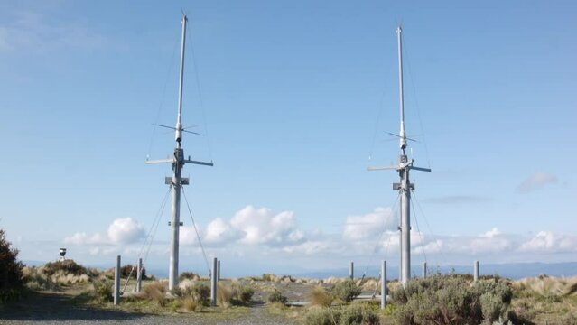 Two tall antenna on top of a mountain