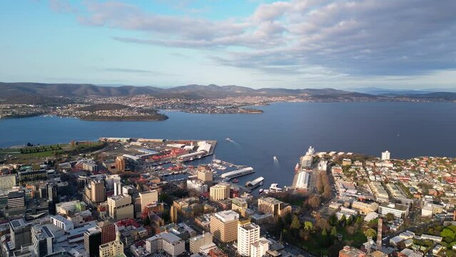 Hobart, Australia: Aerial drone footage of the Hobart central business district and Wharf harbor in Tasmania main city on a sunny day. Shot with a backward motion