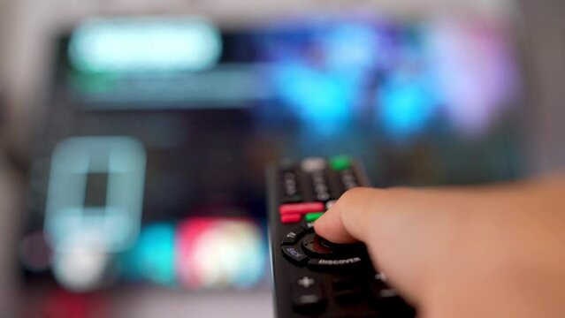 On holidays, people relax at home and watch movies or series. In the living room or living room The person lifts the remote and presses a button to turn on the TV.