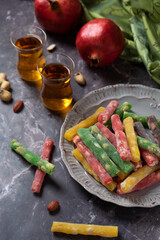 Turkish delights with fruity flavors, multi-colored, top view of Turkish tea drinking, dark key.