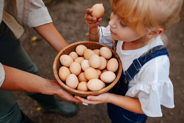 Little girl taking an egg from a bowl