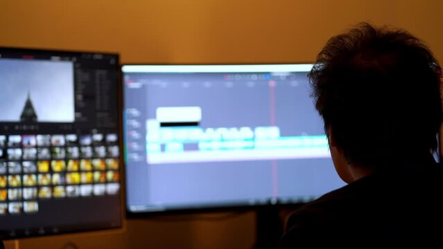 Male video editor using Footage in the production company make a cut By using a computer with an editing program to work.	