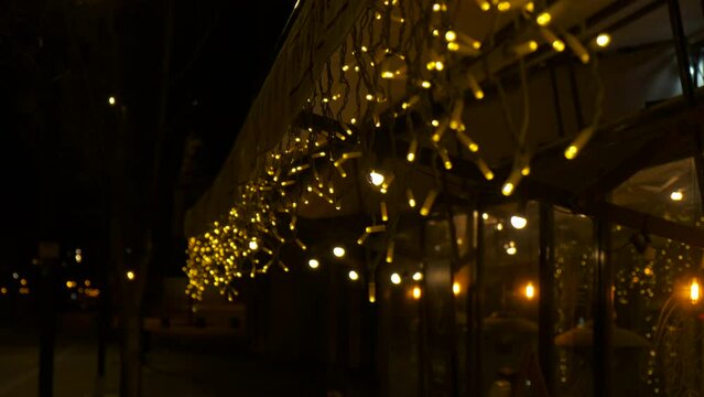 Yellow night decorative lights on caffee. Pretty yellow decorative lights under caffee entrance during night time.