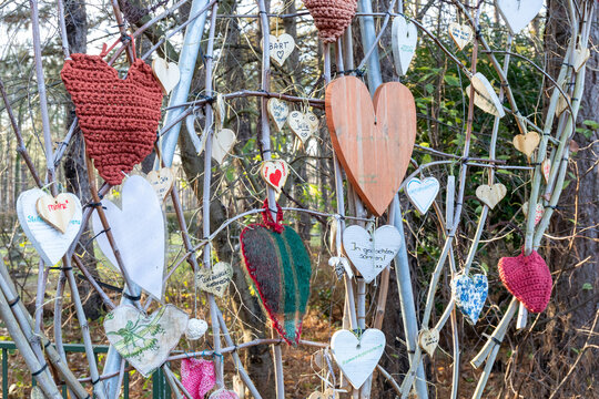 Herdenkingsboom vol met harten uitgevoerd in diverse materialen, ieder hart is een symbool van iemand die overleden is.