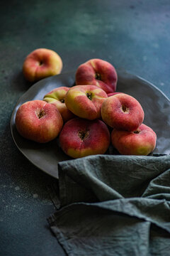 Close-up of a bowl of flat peaches