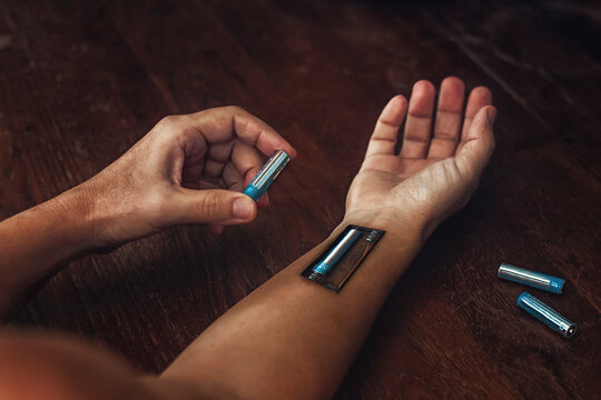 Conceptual image of a tired man recharging his battery