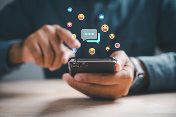 Home office scene man uses smartphone, typing for live chat and social network concepts. Chat box icons pop up, digital communication, social media marketing. Social media marketing technology