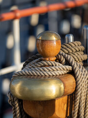 Close-up shot of a brass and wooden bollard on a historic sailing ship