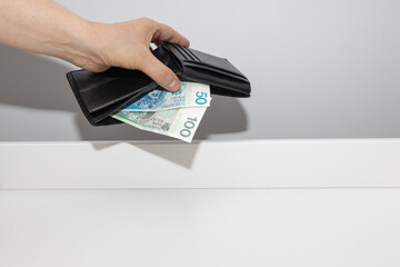 A hand holding wallets with banknotes in Polish denominations. the concept of rising spending and...