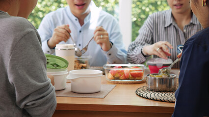 Gen Z asia people group save the planet earth relax eating food go green meal eco friendly glass lunch box reduce plastic waste free water bottle at table SDGs office. ESG net zero happy staff team.