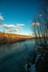Sunset in forest with frozen lake. Naked tress, red sunset.
Sand career 