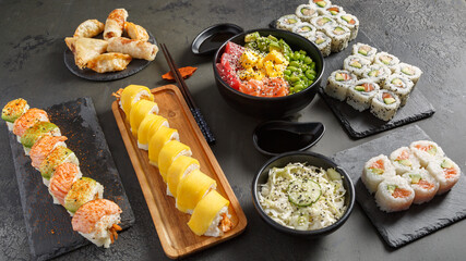 Assortiment des plats japonais: sushi, maki, california rolls, brochettess, soupe miso, salade de choux, poke bowl sur des ardoises et fond noir. Ensemble de cuisine japonaise. - obrazy, fototapety, plakaty